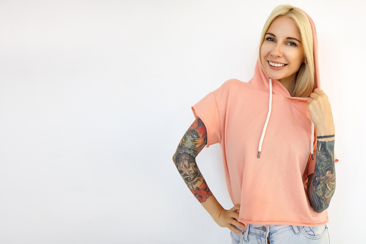 Immagine di un braccio con un tatuaggio parzialmente coperto da un cerotto.